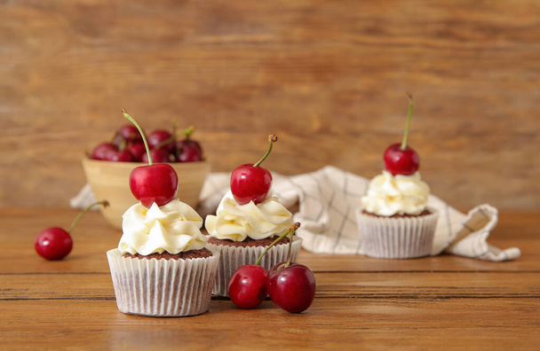 Chutné třešňové cupcakes na dřevěném pozadí - Fotografie, Obrázek