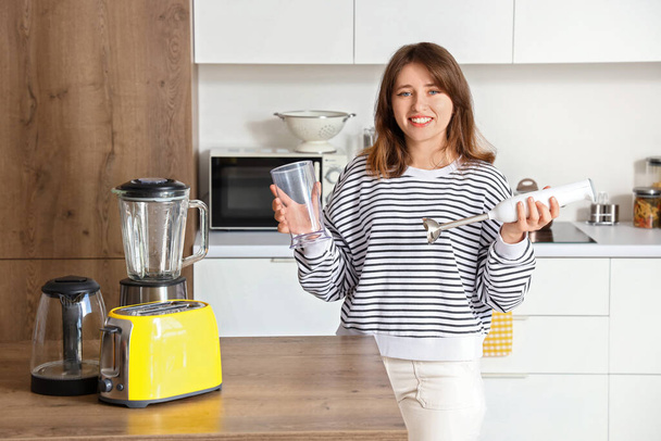 Fiatal nő turmixgéppel a modern konyhában - Fotó, kép