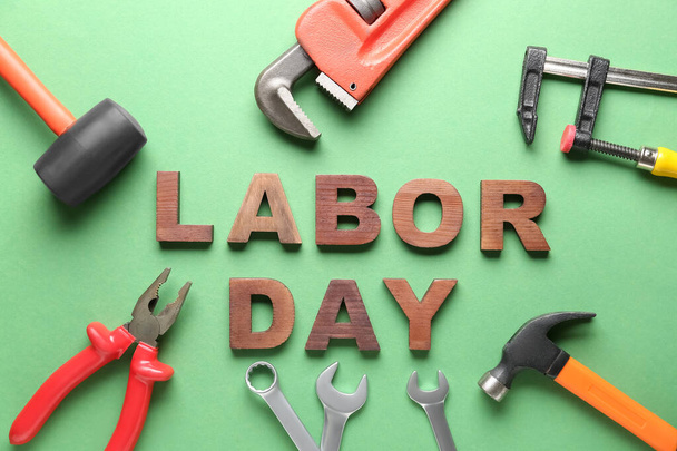 Composition with different tools and text LABOR DAY on green background - Fotoğraf, Görsel