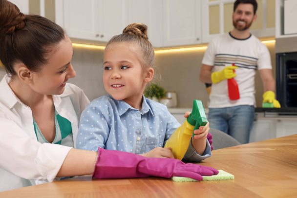 Spring cleaning. Happy family tidying up kitchen together - Zdjęcie, obraz