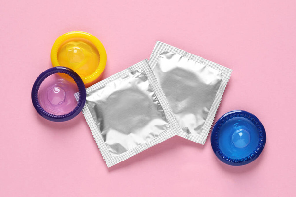 Condoms on pink background, flat lay. Safe sex - 写真・画像