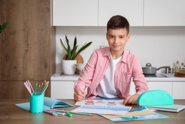 Petit garçon avec un dessin au crayon à la table dans la cuisine - Photo, image