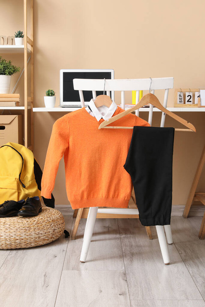Stylish interior of children's room with modern laptop and school uniform - Photo, Image