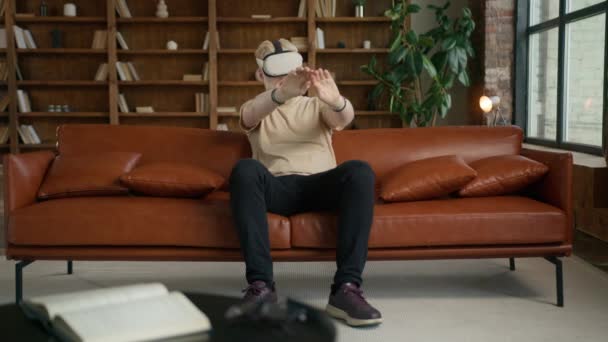 VR Virtual Reality Internet-Konzept. Blonder Hipster benutzt Headset für 3D Cyberspace. Junger Mann durchsucht Webseiten und schiebt Seiten zu Seiten, schaut Video-Streaming-Dienste, nutzt Social Media 4K - Filmmaterial, Video
