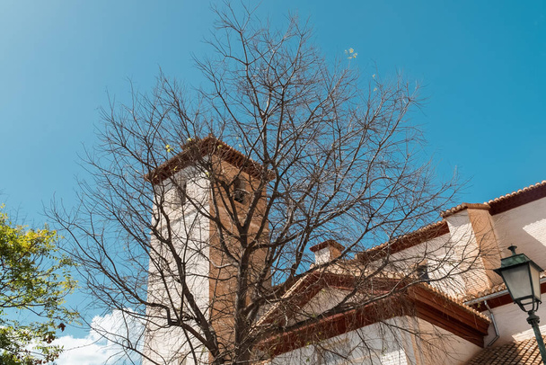 Granada, Spanyolország. 2022. április 17.: A Szent Miklós templom és a kék ég építészete és homlokzata. - Fotó, kép