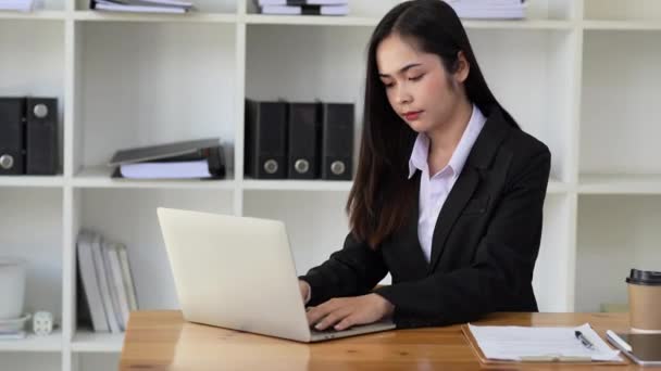 bizneswoman siedzi przy biurku i pisze na laptopie w biurze. Koncepcja technologii biznesowych. - Materiał filmowy, wideo