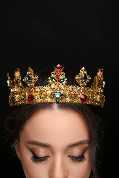 Beautiful young woman wearing luxurious crown on black background, closeup - Fotografie, Obrázek