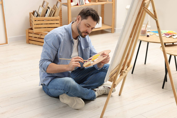 Handsome man painting in studio. Creative hobby - Photo, Image