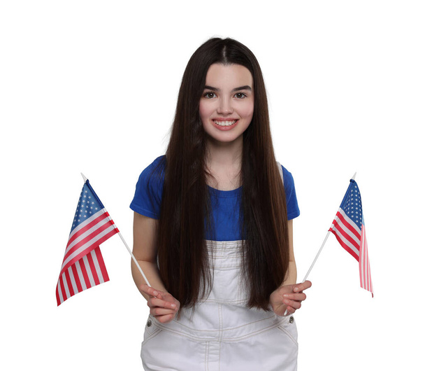 4th of July - Independence day of America. Happy teenage girl holding national flags of United States on white background - Foto, Imagem