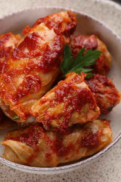 Delicious stuffed cabbage rolls cooked with homemade tomato sauce in bowl, above view - Foto, Bild