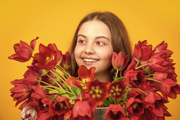 cheerful girl hold spring tulip flowers on yellow background. - Fotoğraf, Görsel