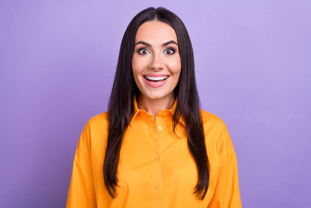 Photo of unexpected reaction young funny girl brunette wear orange shirt surprised promotion career growth isolated on violet background. - Фото, изображение