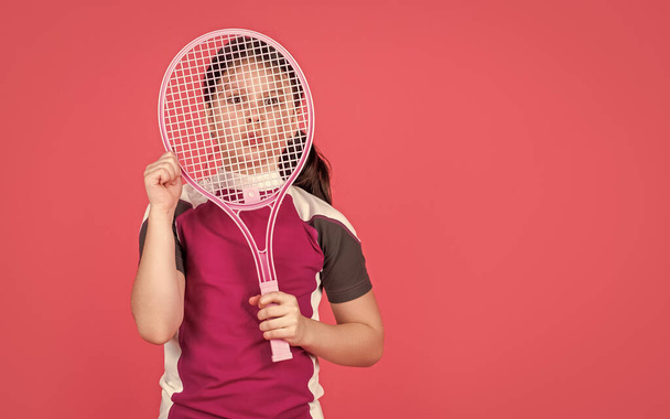 kid hold tennis racket on pink background with copy space. - Foto, afbeelding