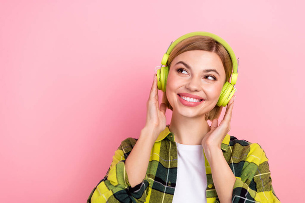 Portrait of minded positive girl toothy smile arms touch headphones look empty space isolated on pink color background. - Φωτογραφία, εικόνα