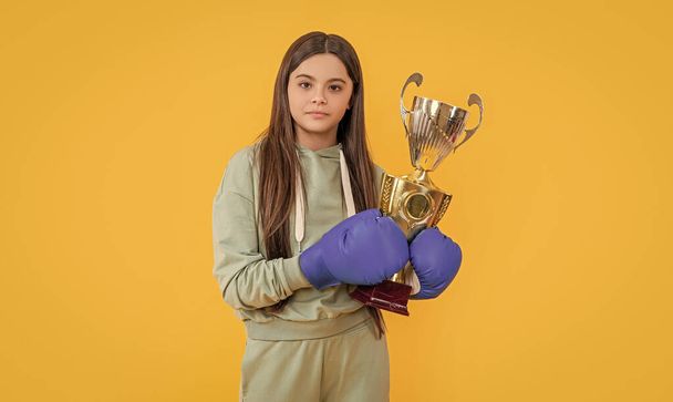 teen boxing girl isolated on yellow. teen boxing girl in studio. teen boxing girl on background. photo of teen boxing girl with champion cup. - Valokuva, kuva