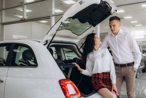 Giovane coppia stringere la mano con l'agente di vendita dopo un acquisto di auto di successo
 - Foto, immagini