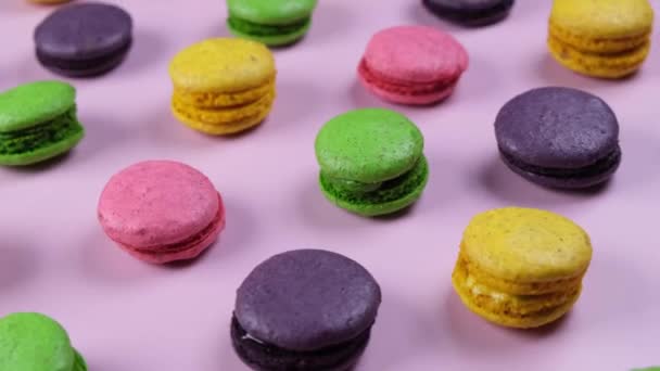  fondo de galletas de macarrones dulces en diferentes colores sobre un fondo rosa. Imágenes de alta calidad 4k - Metraje, vídeo