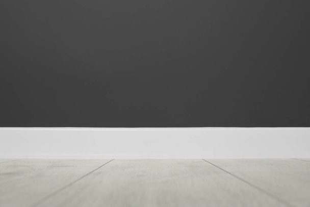 White plinth on laminated floor near black wall indoors - Valokuva, kuva