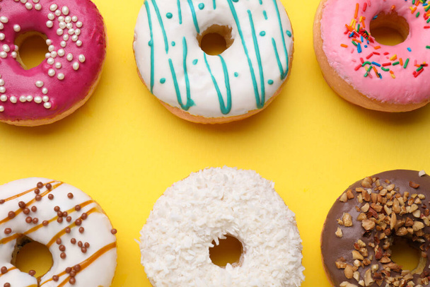Tasty glazed donuts on yellow background, flat lay - Photo, image