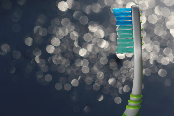 歯ブラシにはボケの背景に歯磨き粉が分離されています。ナイロン毛とプラスチックハンドル。広告テキストの空白のコピースペース. - 写真・画像