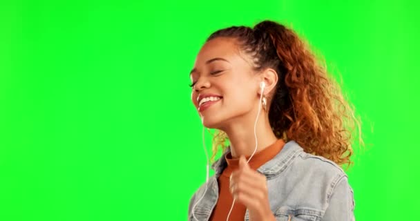 Happy woman, dance and listening to music on green screen against a studio background. Female person with earphones, radio and enjoying audio, streaming or sound track for fun on mockup space. - Footage, Video