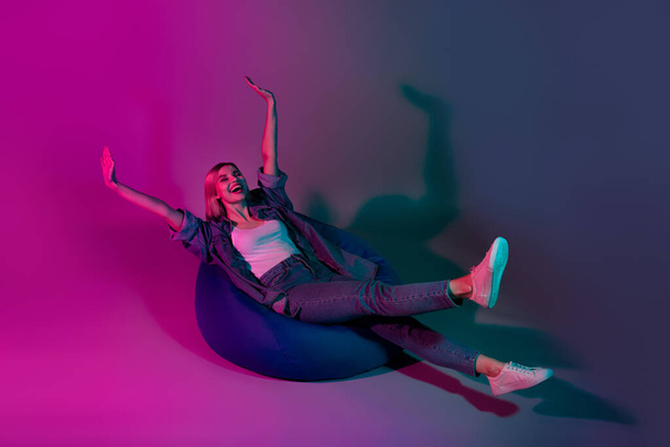 Photo of positive cheerful lady rest relax imagine ride on armchair isolated on fluorescent neon color background. - Φωτογραφία, εικόνα
