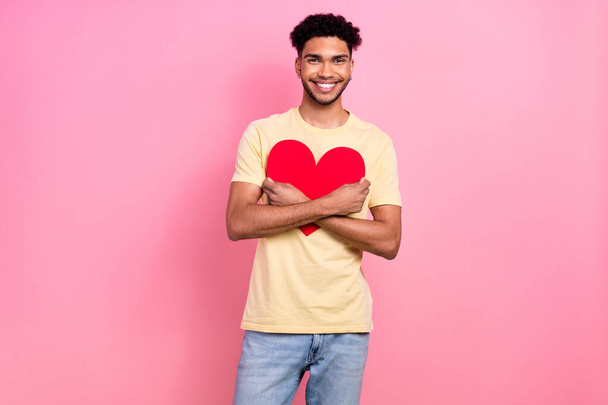 Photo young boyfriend guy hold close to chest embrace big red paper heart wear shirt jeans isolated pink color background. - Fotó, kép