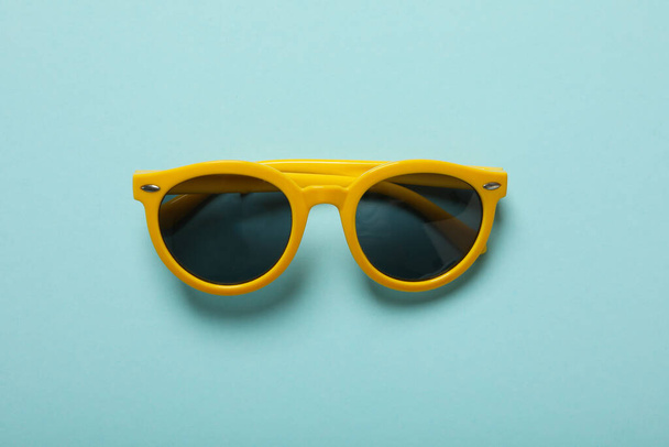 Sunglasses on a blue background, top view - Foto, Imagen