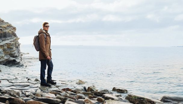 Traveler man standing on coastline - Photo, Image