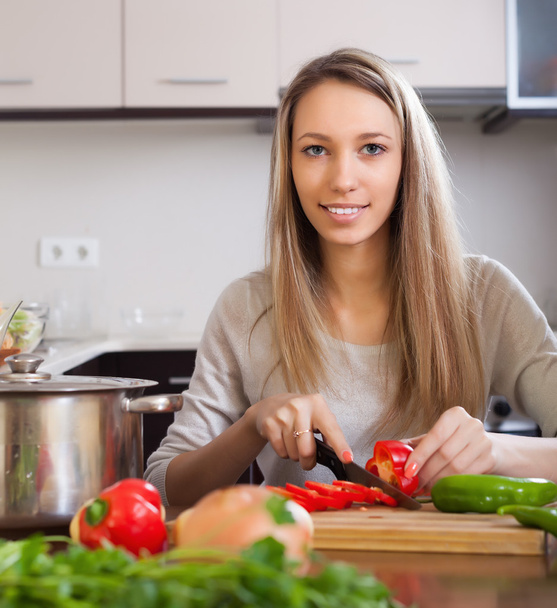 Blonde woman slicing red pepper - Photo, image
