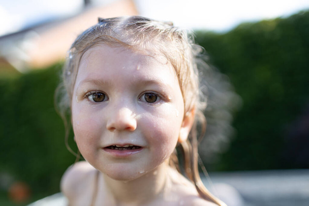 Child in an outdoor bath tube in the backyard in summertime - Fotografie, Obrázek