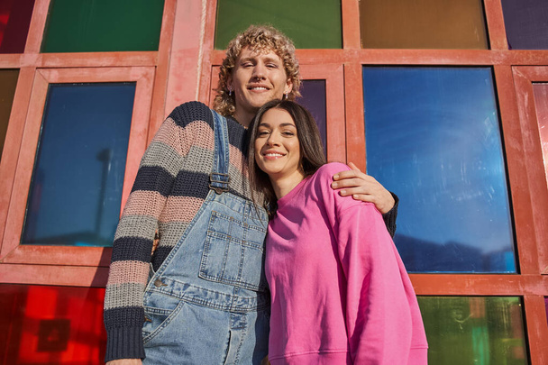 Trendy millennial couple smiling toothy and posing to the camera at sunny street. People lifestyle concept. Stock photo - Foto, Imagem