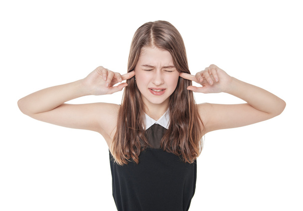 Jeune belle adolescente bouchant les oreilles avec les doigts isoler
 - Photo, image