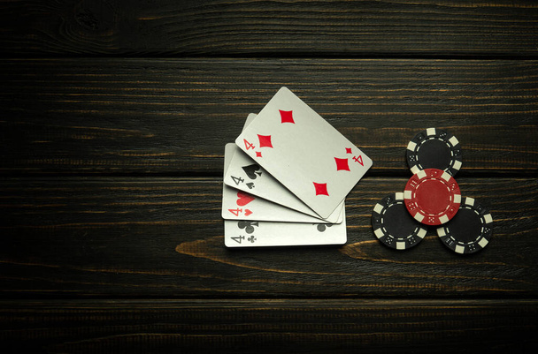Jeu de poker avec quatre combinaisons aimables. Chips et cartes sur la table vintage noire. Victoire réussie et maximale. Espace de copie. - Photo, image