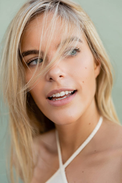 Una giovane, bella donna bionda a Miami sorride, indossando un top bianco in una giornata di sole. - Foto, immagini