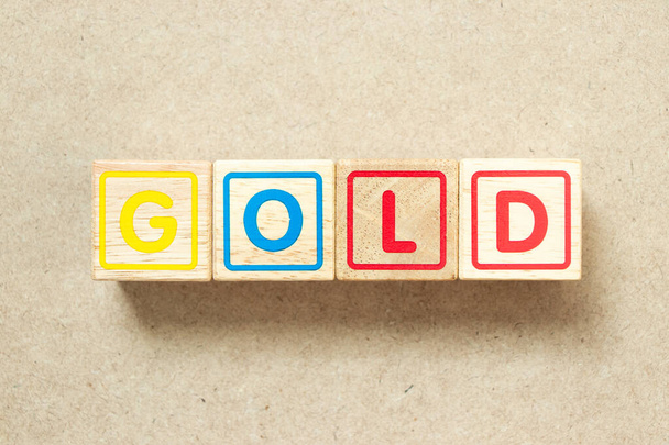Wooden alphabet letter block in word gold on wood background - 写真・画像