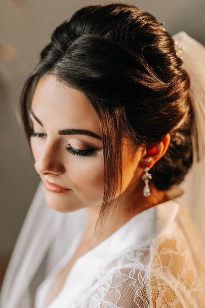 Adult girl, bride, with wedding hairstyle and makeup, half profile photo. Preparation for the wedding ceremony. - Foto, afbeelding