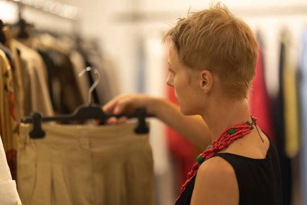 Взрослая стильная женщина-модный консультант в бутике. Средний выстрел - Фото, изображение