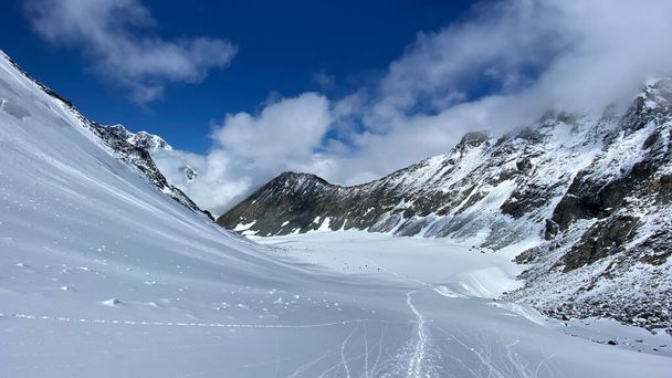 Top view of the snow-covered Delaunay pass. Climbing Mount Belukha. Altai Mountains. Beautiful mountain landscape. Amazing natural background. Blue sky and white clouds. - Zdjęcie, obraz