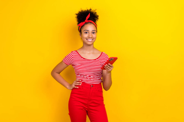 Photo of pretty adorable lady wear striped red t-shirt chatting instagram twitter telegram facebook isolated yellow color background. - Foto, Imagem