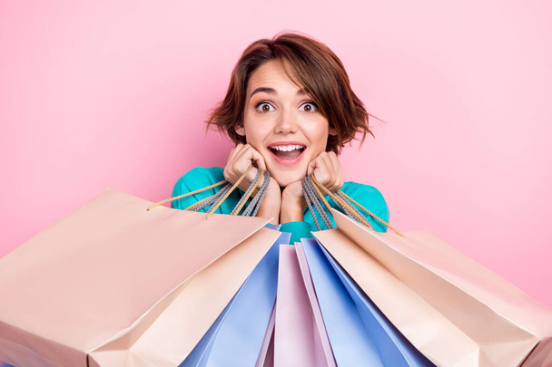Portrait of astonished cheerful lady hold many packs impressed low price stylish clothes isolated on pink color background. - Фото, изображение