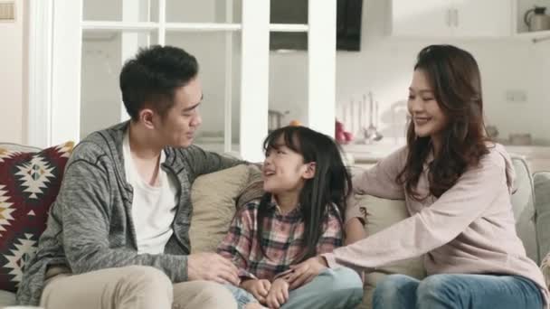 kochający młody Azji para rodzice siedzi na kanapie mając a rozmowa z córka w domu - Materiał filmowy, wideo