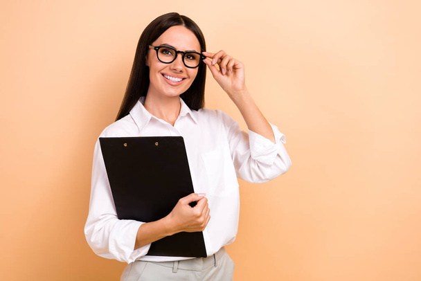 Photo of cheerful charming lady wear white shirt spectacles holding documents empty space isolated beige color background. - Φωτογραφία, εικόνα