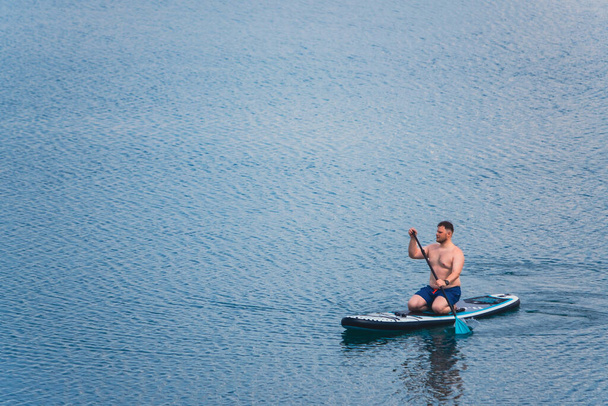 man on paddleboard in the middle of the lake copy space - Foto, Bild