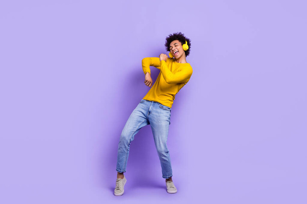 Full length photo of handsome nice guy wear stylish sweatshirt headphones dancing in disco club isolated on violet color background. - 写真・画像