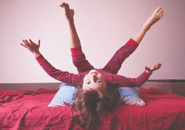 I do not want to sleep yet. Funny portrait of cute active little girl having fun and doesn't want going to fall asleep. (Happy childhood, rest, dream, kids concept). Horizontal image. - Fotó, kép