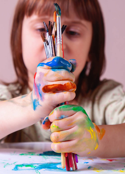 Mała dziewczynka trzyma pędzel do malowania. Sztuka, kreatywność, koncepcja z dzieciństwa piękna. - Zdjęcie, obraz