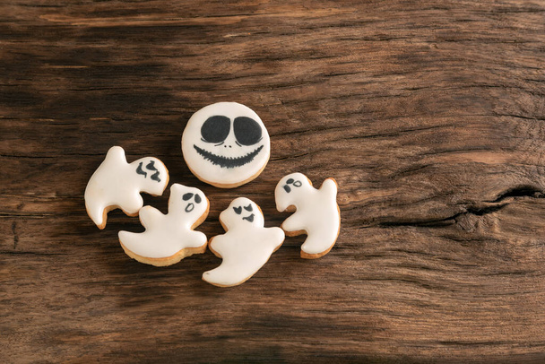 Biscuits au pain d'épice sous forme de fantômes sur une surface rugueuse en bois. Vue de dessus. Bonbons pour Halloween - Photo, image
