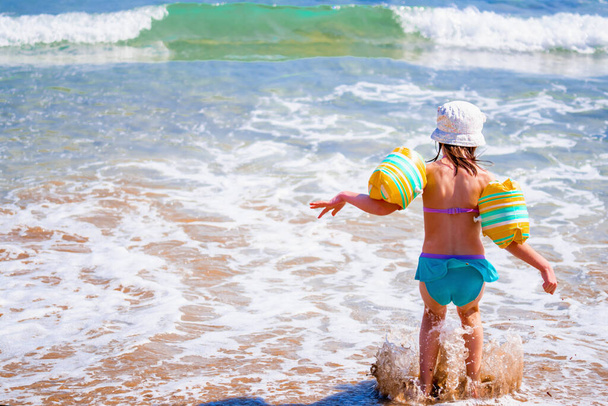 Καλοκαιρινές διακοπές. Νεαρό ελκυστικό όμορφο κορίτσι χαλαρώνοντας και απολαμβάνοντας στο νερό της θάλασσας την ηλιόλουστη μέρα του καλοκαιριού. - Φωτογραφία, εικόνα