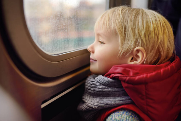 Little boy looks out the window of the car in the subway in New York, USA. Family travel with children. - Foto, Bild